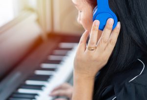mulher tocando e ouvindo o som do piano