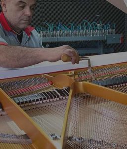 Homem fazendo assistência técnica no piano